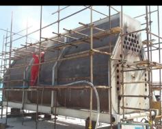 Mantenimiento de calentador con andamiaje y acceso controlado al equipo de proceso.